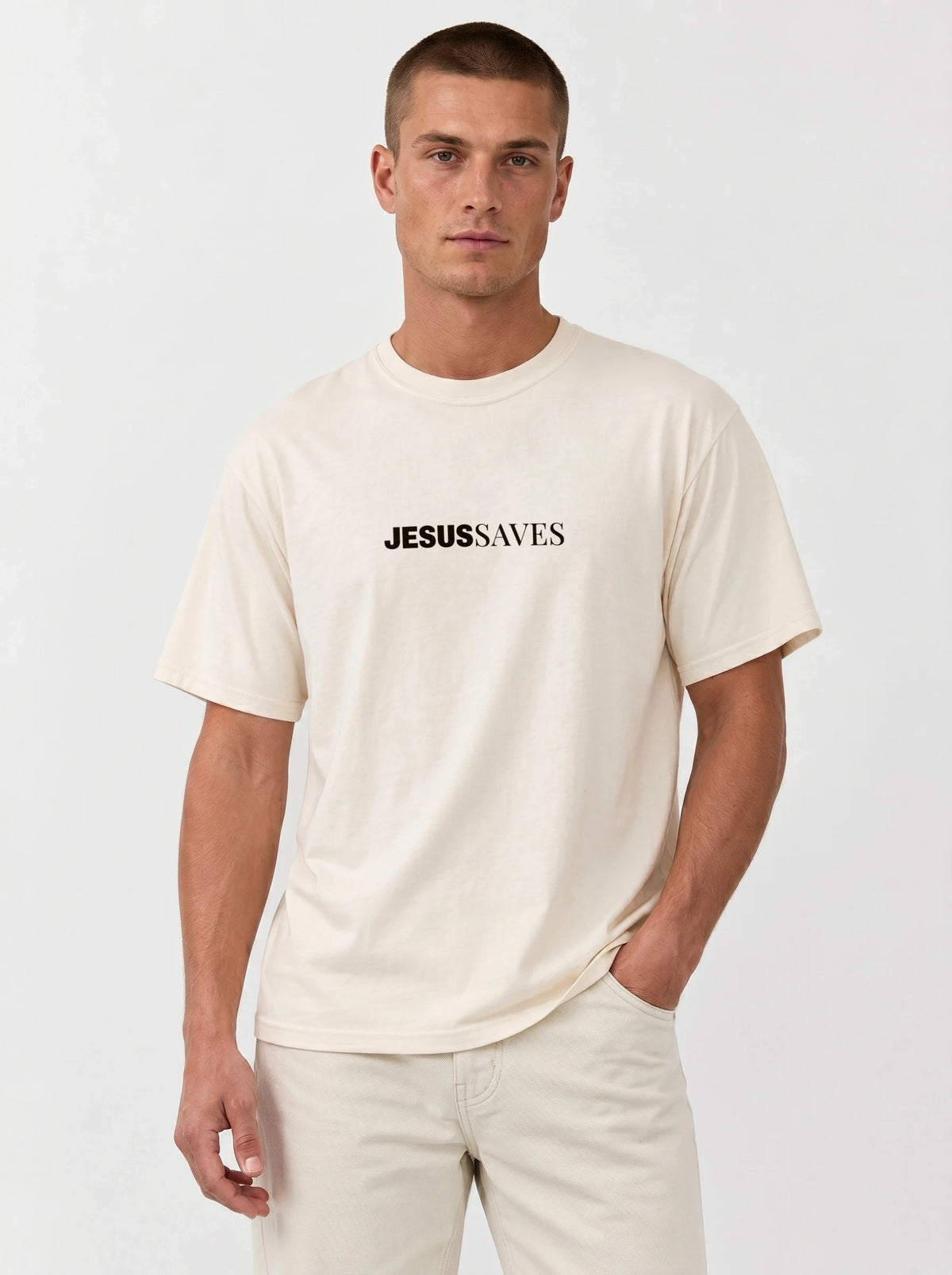 Person wearing a cream T-shirt with black chest text reading “Jesus Saves.”