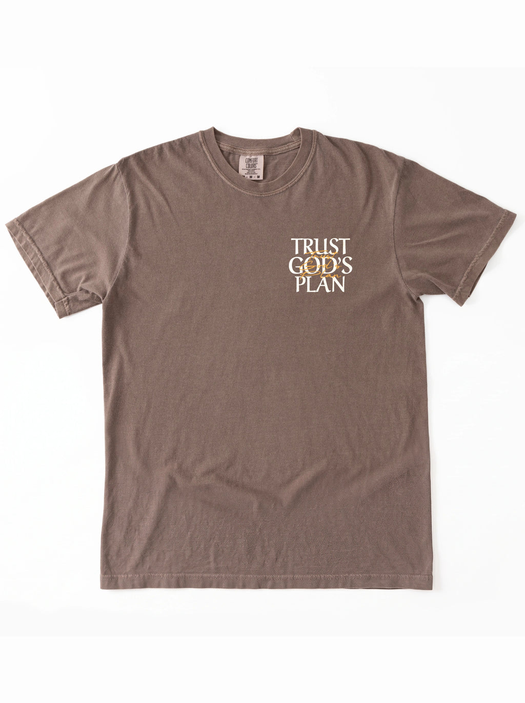 Faded brown T-shirt laid flat with a small chest design reading “TRUST GOD’S PLAN.”