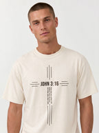 Person wearing a cream T-shirt with a black cross design reading “John 3:16” and “For God so loved the world that he gave his one and only son.”