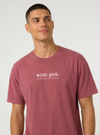 A man wearing a heathered dusty rose t-shirt with the white printed text 'with god. all things are possible' on the chest, photographed against a light gray studio background.