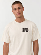 Person wearing a cream T-shirt with a small distressed chest print reading “The Way The Truth The Life.”