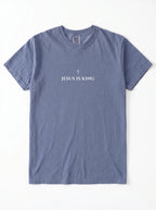 Muted blue T-shirt laid flat with a small cross above the text “Jesus Is King.”