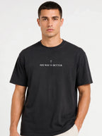 Person wearing a black T-shirt with a small cross above the text “His Way Is Better.”