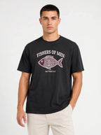 A man wearing a black graphic t-shirt with a white and purple fish design and the text 'FISHERS OF MEN' and 'MATTHEW 4:19'.