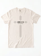 Cream T-shirt laid flat with a black cross-shaped design reading “John 3:16” and “For God so loved the world that he gave his one and only son.”