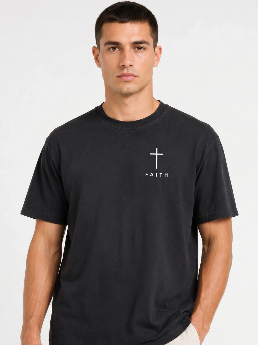 Person wearing a faded black T-shirt with a white cross and “FAITH” printed on the chest.