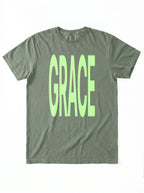 Muted green T-shirt laid flat with large neon green text reading “GRACE.”