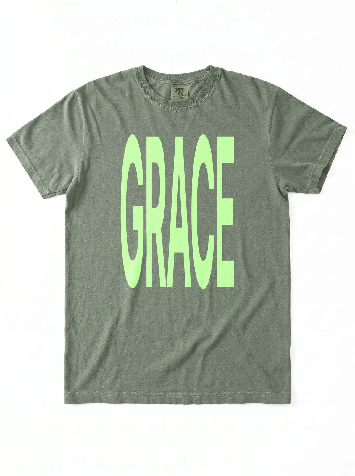Muted green T-shirt laid flat with large neon green text reading “GRACE.”