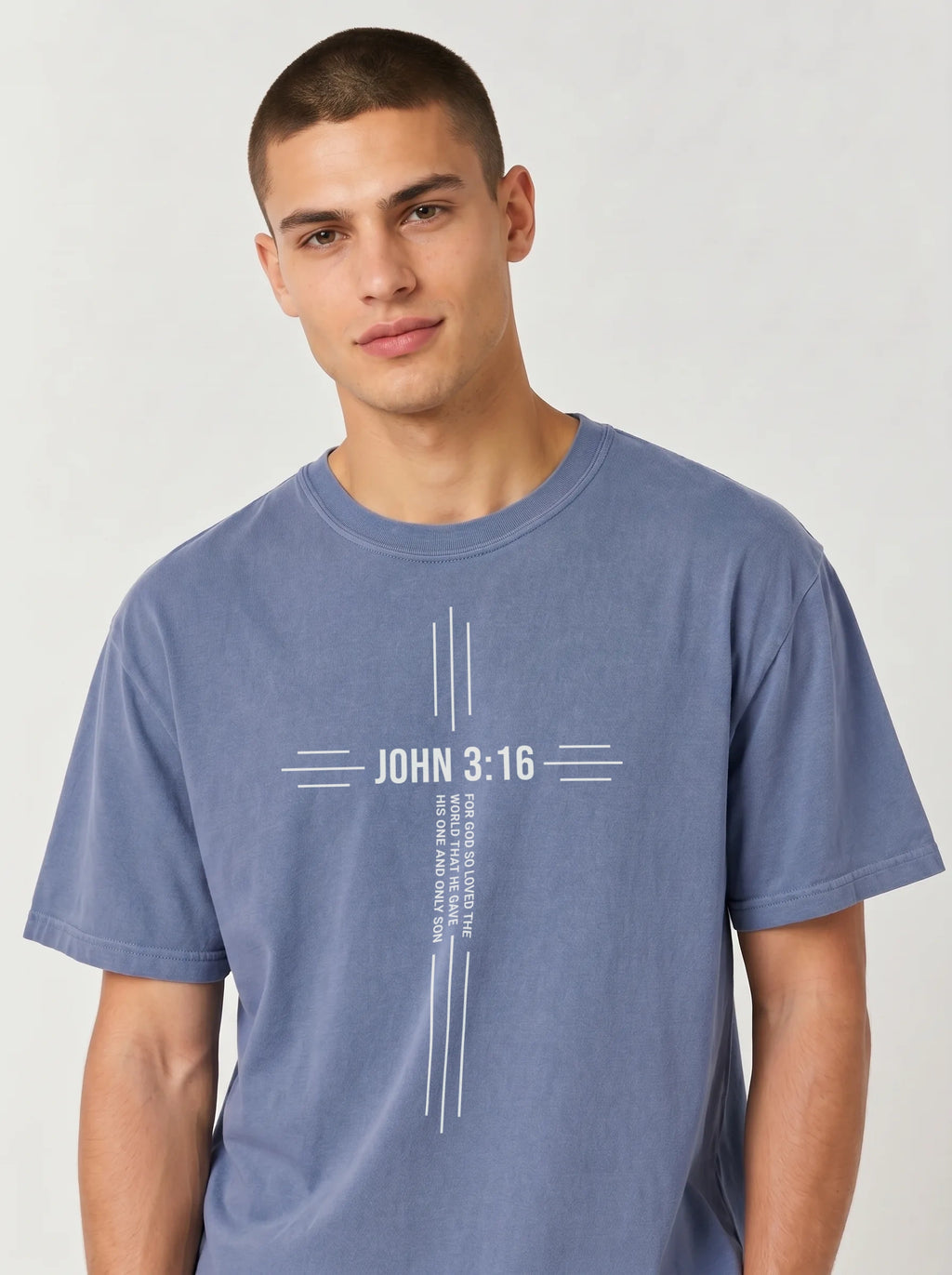 Person wearing a blue T-shirt with a white cross design reading “John 3:16” and “For God so loved the world that he gave his one and only son.”