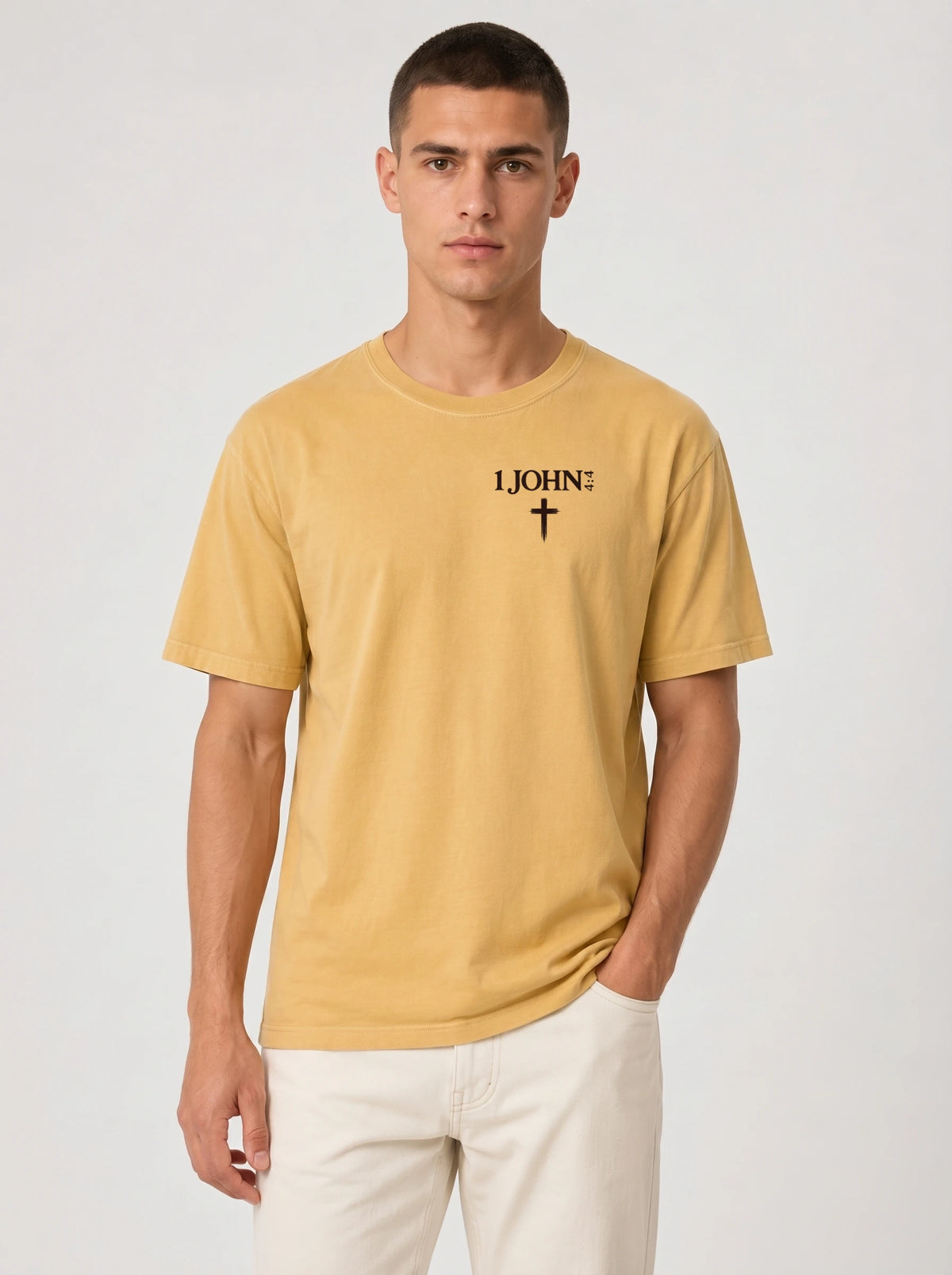 Person wearing a yellow T-shirt with black “1 John 4:4” text and a cross printed on the chest.