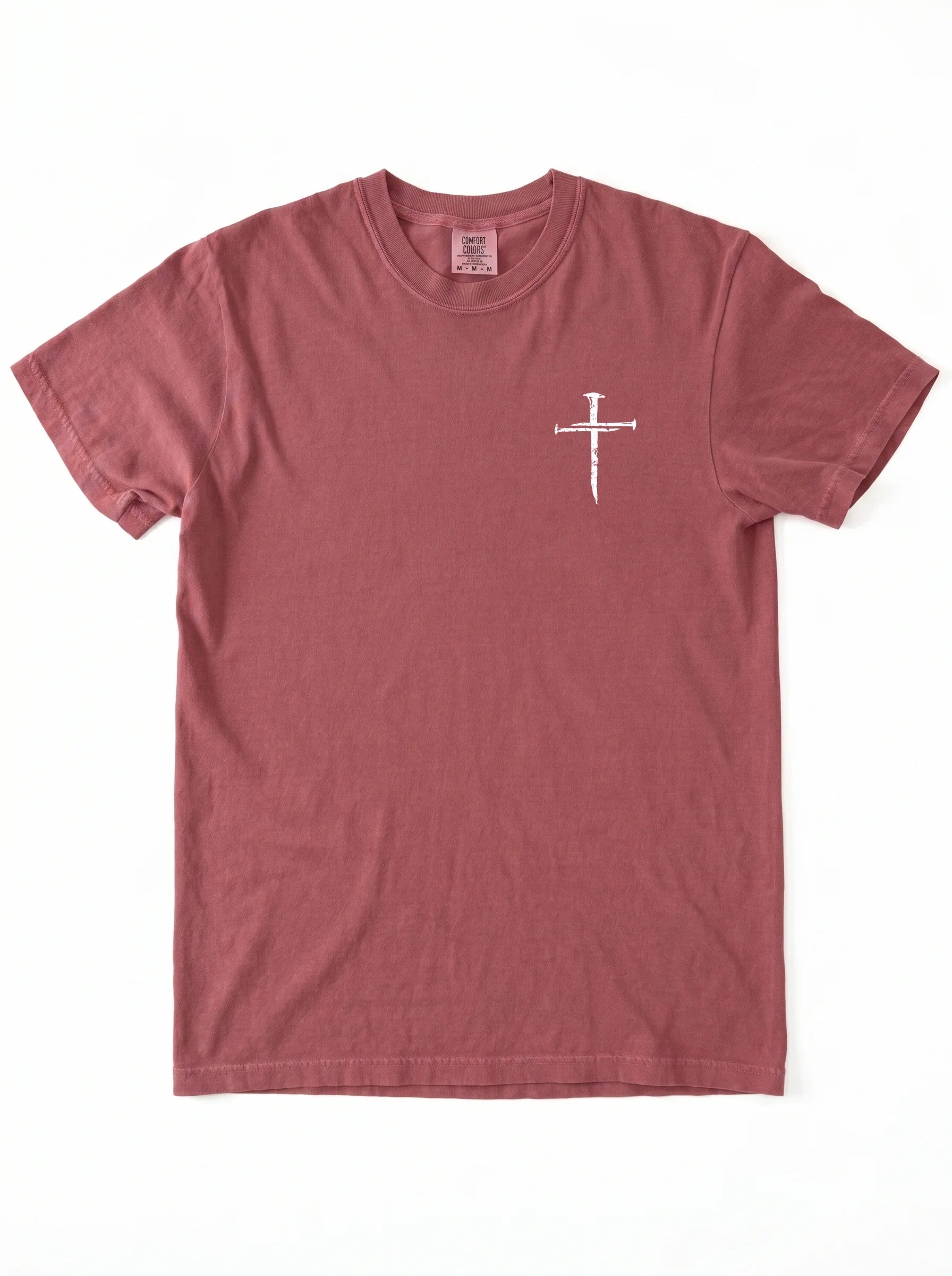 A dusty rose short-sleeve crewneck t-shirt with a small white cross graphic on the left chest, displayed flat against a white background.