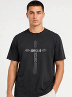 Person wearing a black T-shirt with a white cross design reading “John 3:16” and “For God so loved the world that he gave his one and only son.”