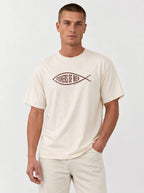 A man wearing a cream-colored t-shirt with a brown fish graphic that reads 'FISHERS OF MEN' across the chest, paired with matching cream pants, against a plain light gray background.