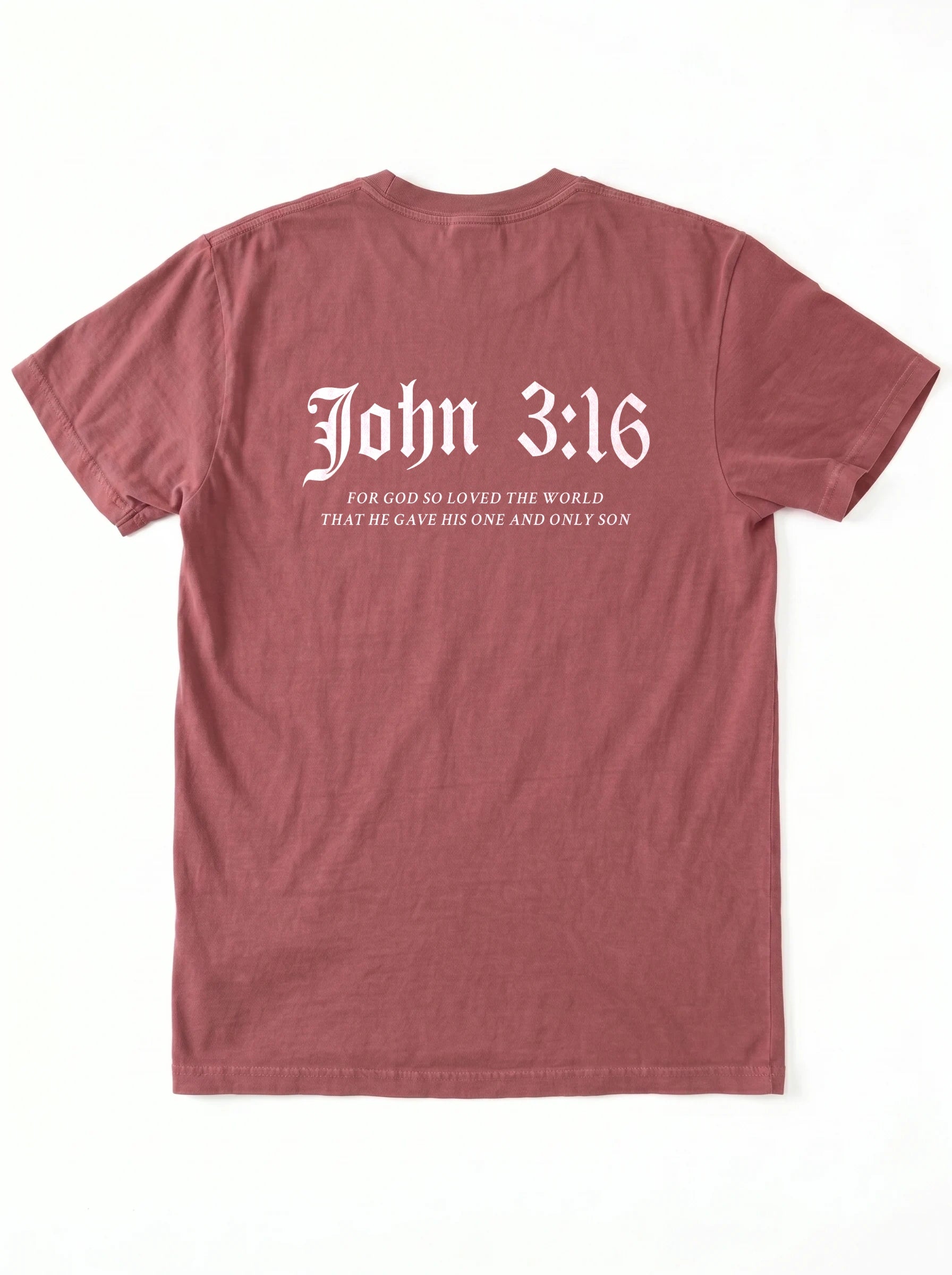 A dusty rose short-sleeve t-shirt shown from the back, featuring the text 'John 3:16' in a white gothic font with a bible verse printed underneath.