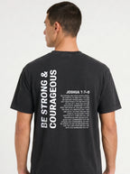 Person shown from behind in a black T-shirt with “Be strong & courageous” and Joshua 1:7–9 printed in white.