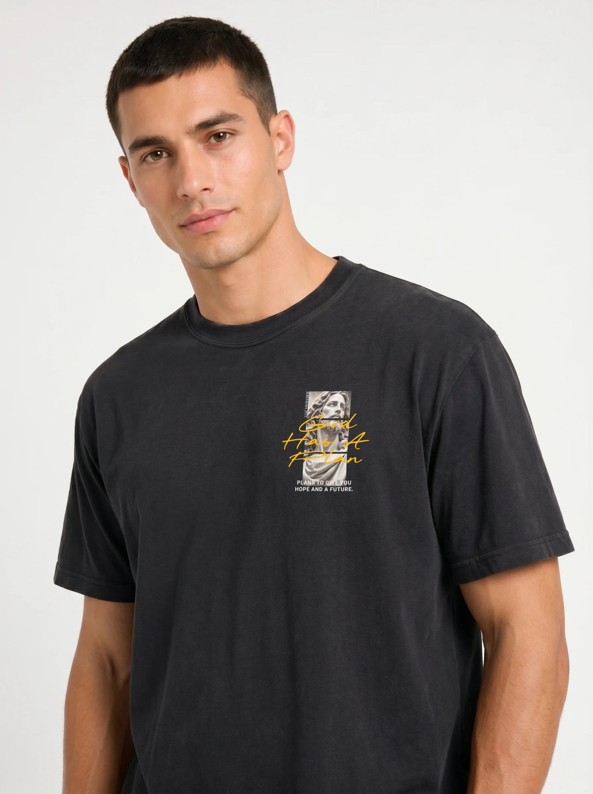 Person wearing a faded black T-shirt with a statue graphic and the text “God Has A Plan” and “Plans to give you hope and a future.”