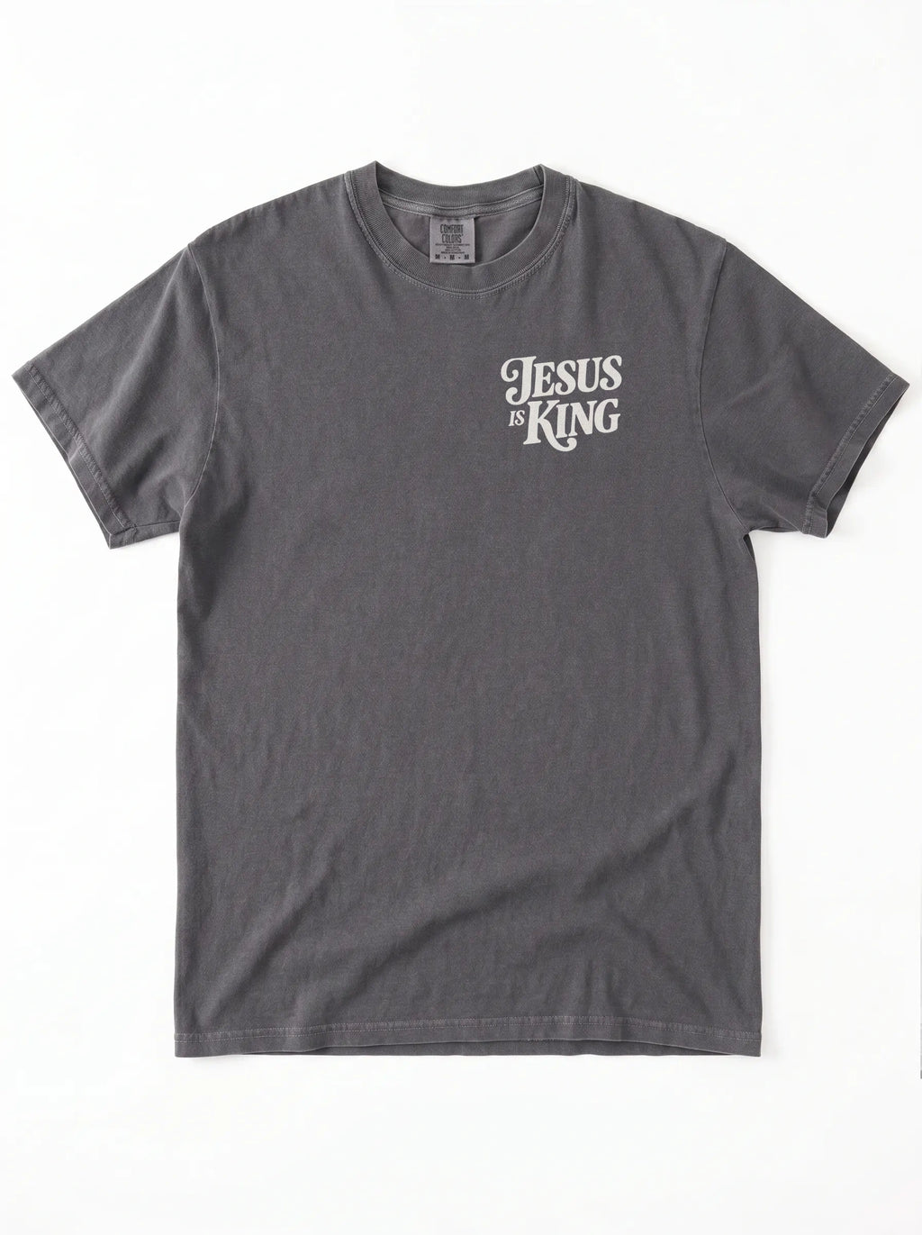Front of a faded gray T-shirt with a small cream “Jesus is King” design on the left chest.