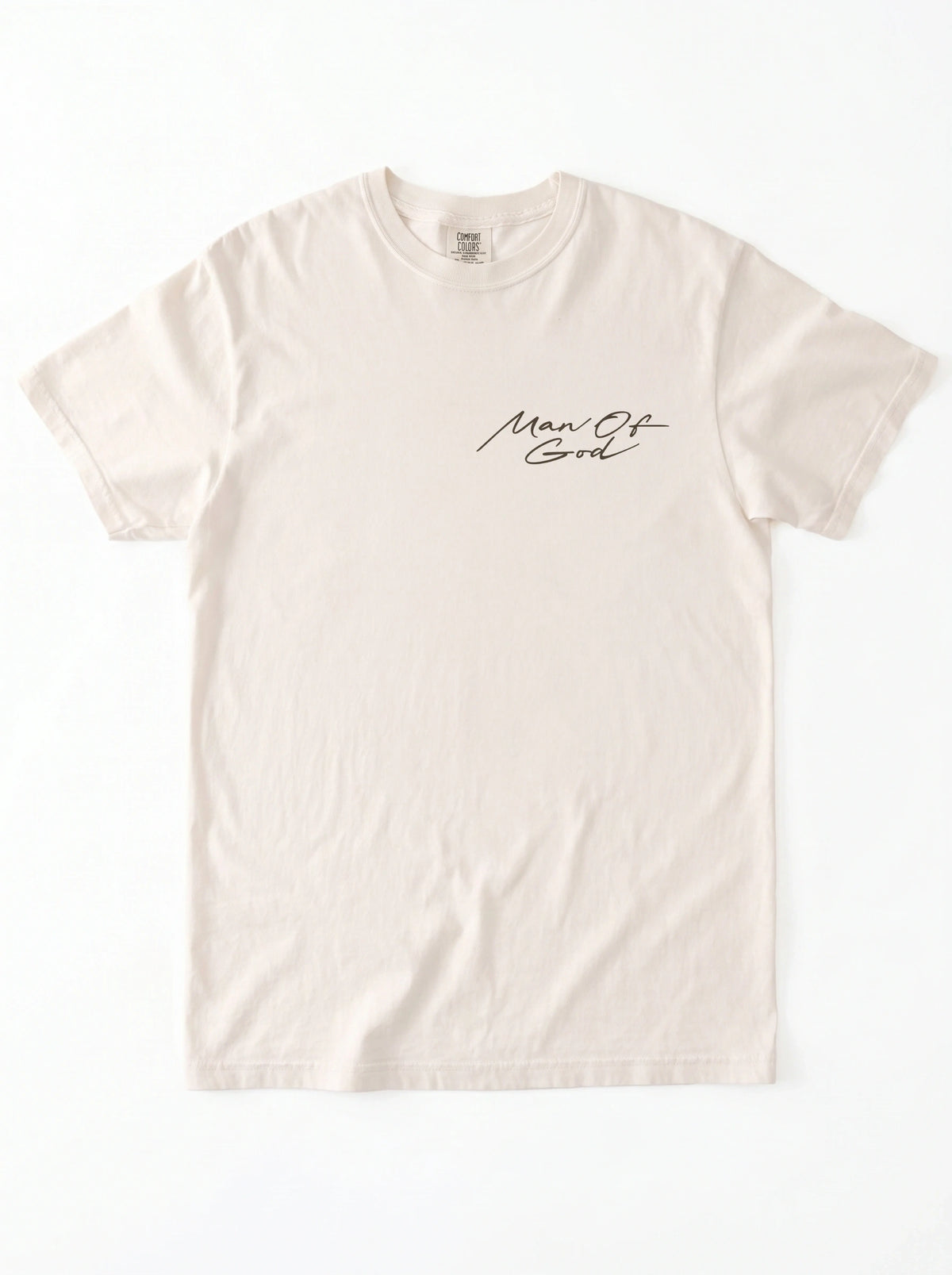 Cream T-shirt laid flat with a small black script chest graphic reading “Man Of God.”