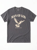 Charcoal T-shirt laid flat with a flying dove and the text “Man of God” and “Romans 8:14.”