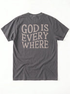 A dark gray crewneck t-shirt shown from the back, featuring the phrase 'GOD IS EVERY WHERE' printed in a distressed, light beige serif font.