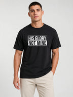 Man wearing black Comfort Colors t-shirt with His Glory Not Mine Christian graphic tee