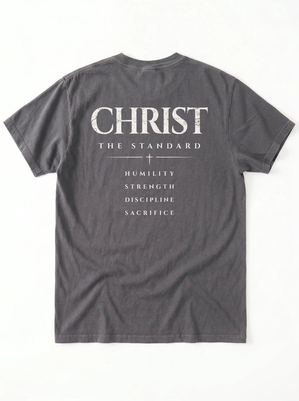Back of a gray T-shirt laid flat with “Christ The Standard,” a small cross, and “Humility, Strength, Discipline, Sacrifice.”