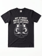 A black short-sleeve crewneck t-shirt featuring a white graphic print of a motivational quote from Jeremiah 4:6 above a pair of boxing gloves. The text reads 'NOT BY MIGHT NOR BY POWER, BUT BY MY SPIRIT'.