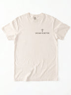A light beige crewneck t-shirt with a small black graphic on the left chest featuring a cross and the text 'HIS WAY IS BETTER'.