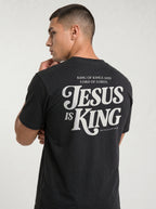 Person wearing a black T-shirt with back text: “King of Kings and Lord of Lords. Jesus is King. Revelation 19:16.”
