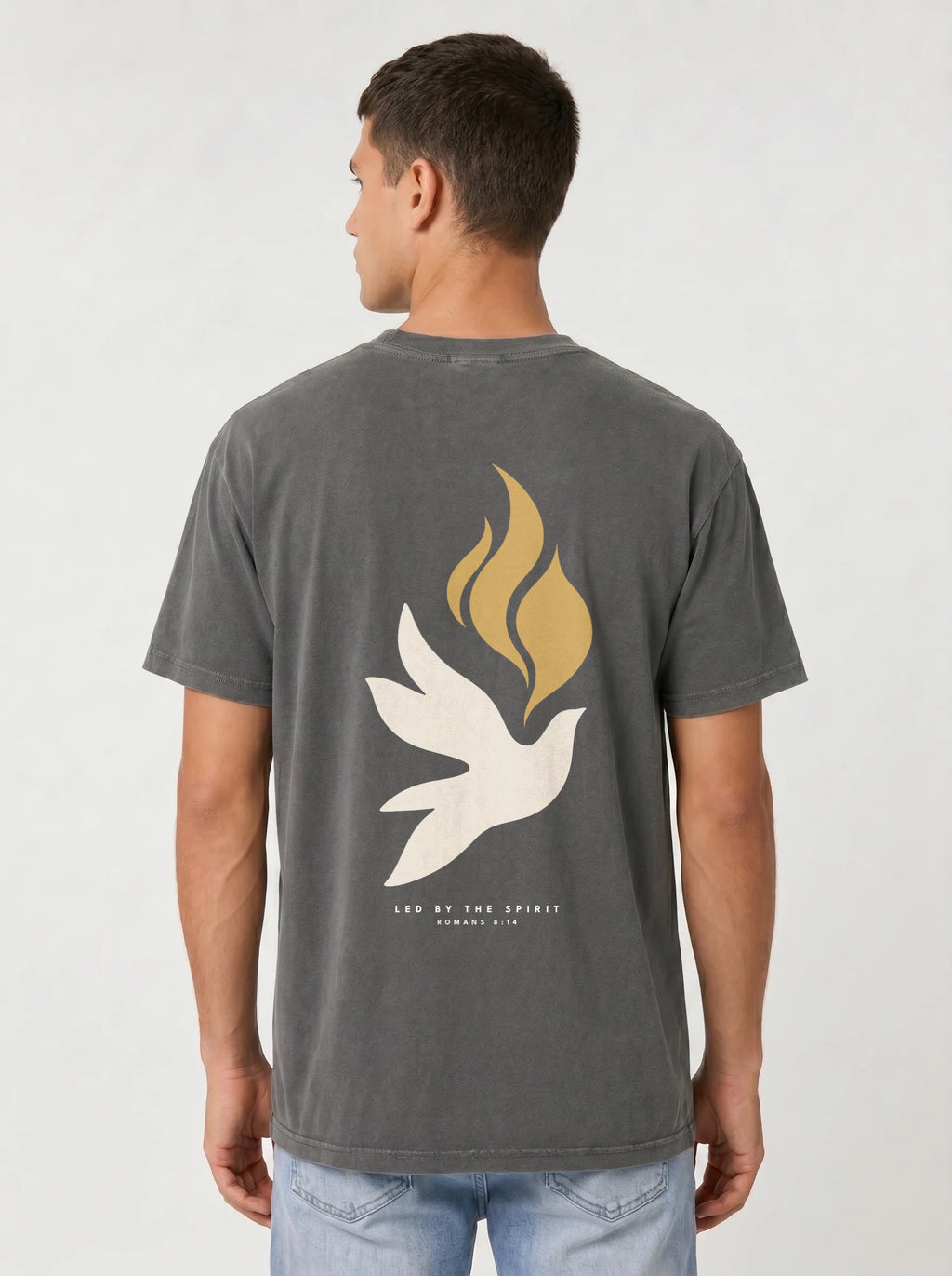 Person wearing a faded charcoal T-shirt with a large white dove, gold flames, and “LED BY THE SPIRIT ROMANS 8:14” on the back.