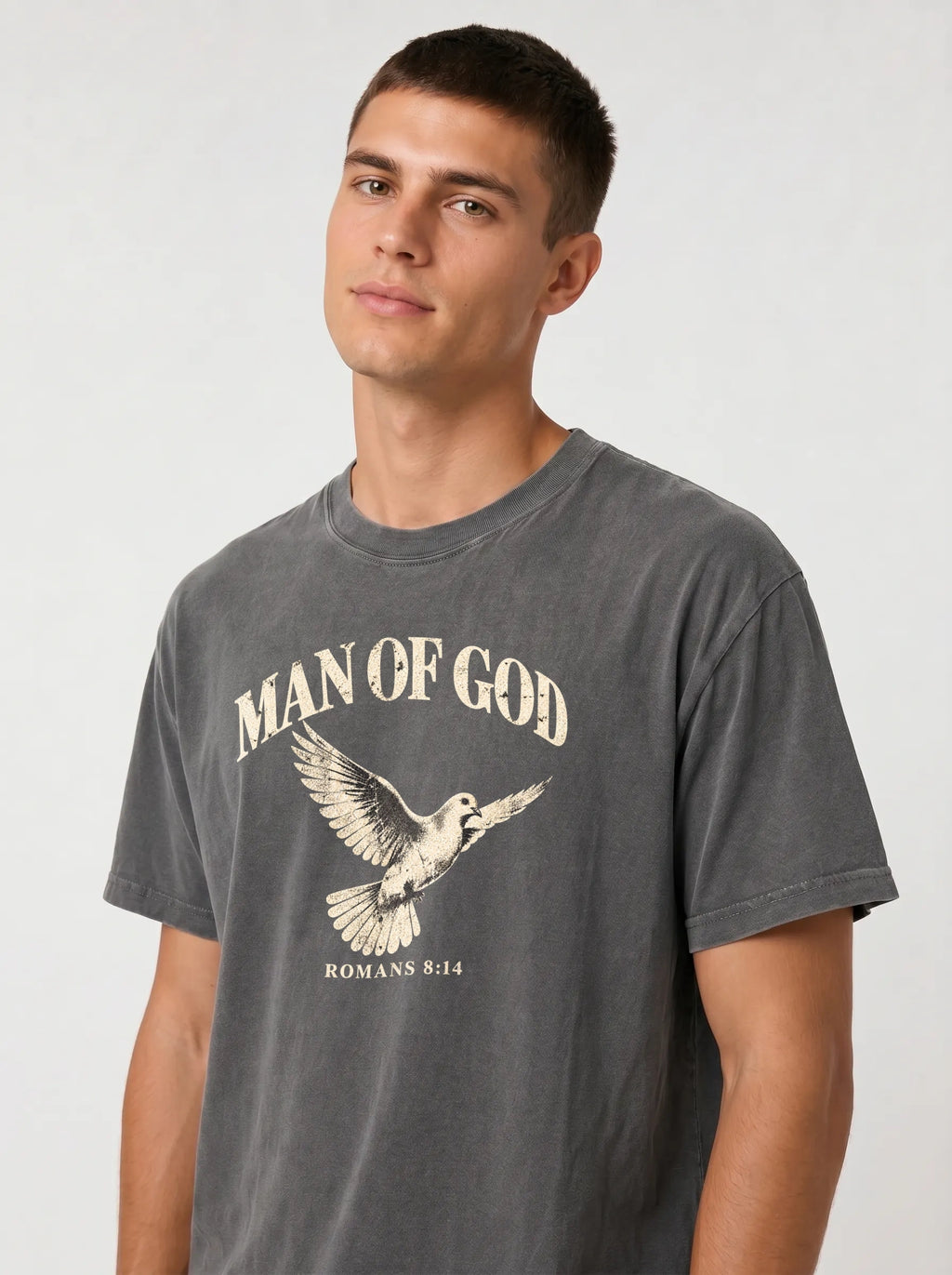 Close-up of a person wearing a charcoal T-shirt with a flying dove and the text “Man of God” and “Romans 8:14.”