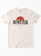 An off-white crewneck t-shirt featuring a distressed graphic of a red half-sunset and the text 'DO NOT FEAR' and 'I AM WITH YOU' in black.