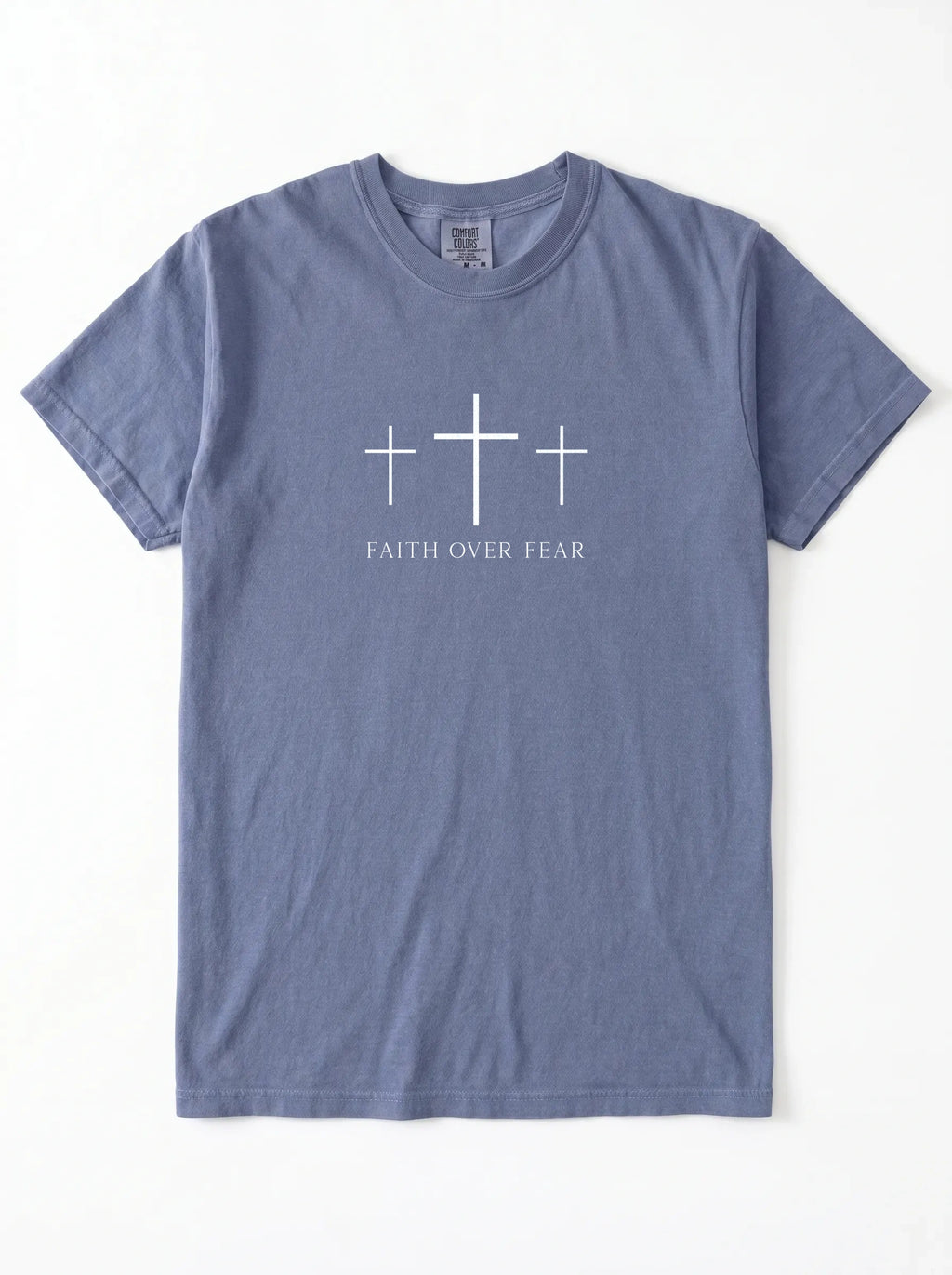 A slate blue crewneck t-shirt with a white graphic on the chest featuring three crosses and the text 'FAITH OVER FEAR'.