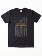 A black short-sleeve crewneck t-shirt featuring a distressed American flag graphic with a central cross made of text reading 'FAITH FAMILY FREEDOM' in gold and gray.