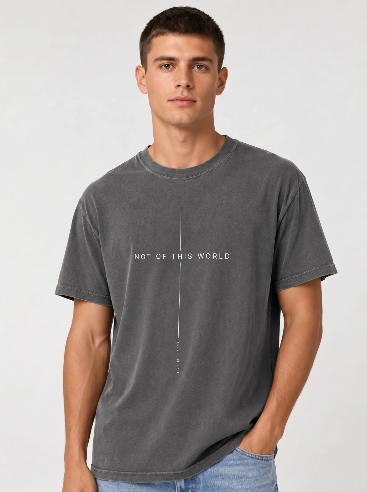 Person wearing a faded gray T-shirt with thin white lines framing the text “Not of This World” and “John 17:16.”