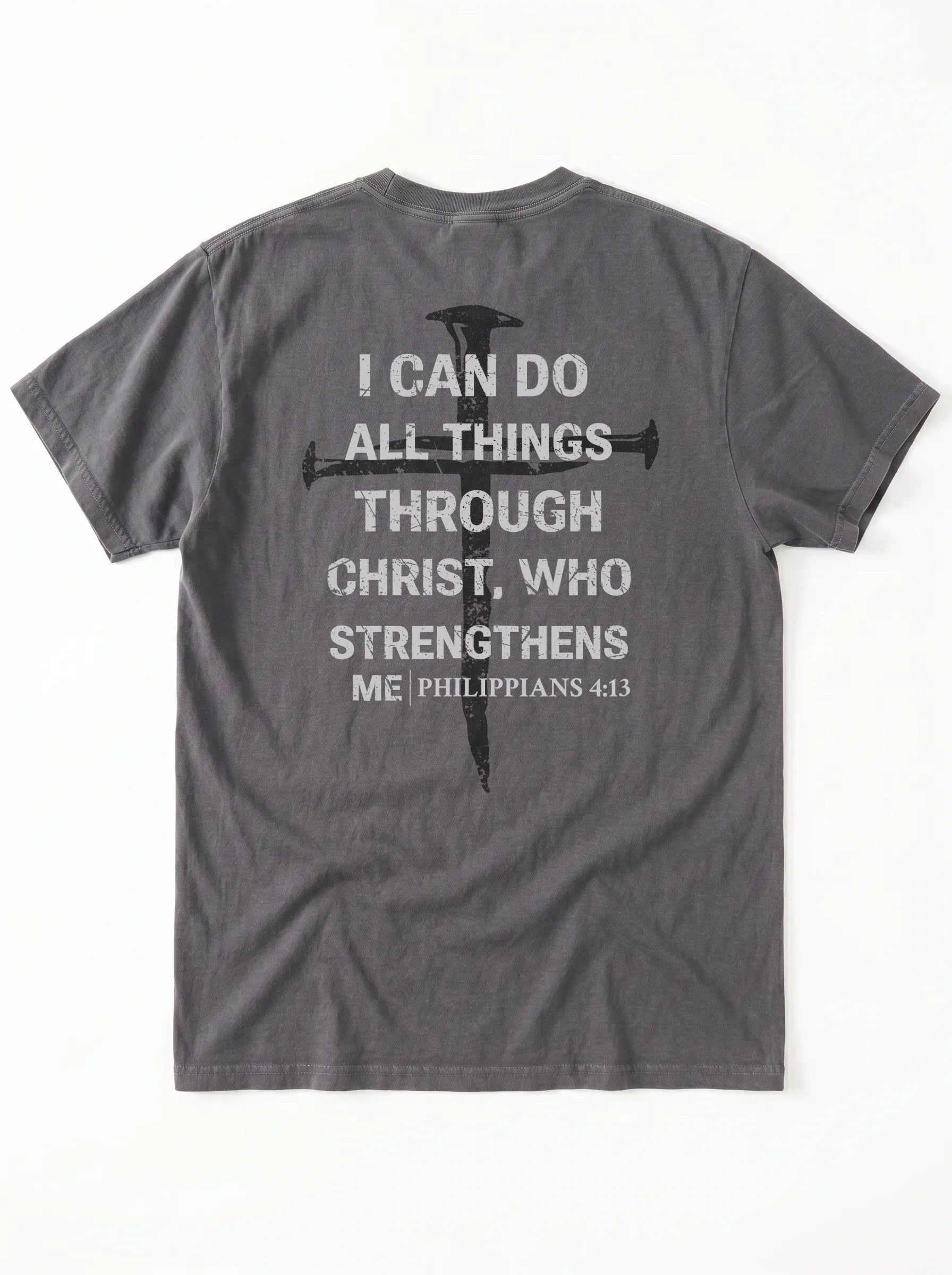 A dark gray crewneck t-shirt shown from the back, featuring a distressed white text graphic of the biblical quote 'I CAN DO ALL THINGS THROUGH CHRIST, WHO STRENGTHENS ME' alongside a black cross design.