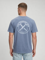 A man viewed from the back wearing a heathered slate blue t-shirt with a distressed white circular graphic on the back that reads 'IRON SHARPENS IRON' and 'PROVERBS 27:17'.