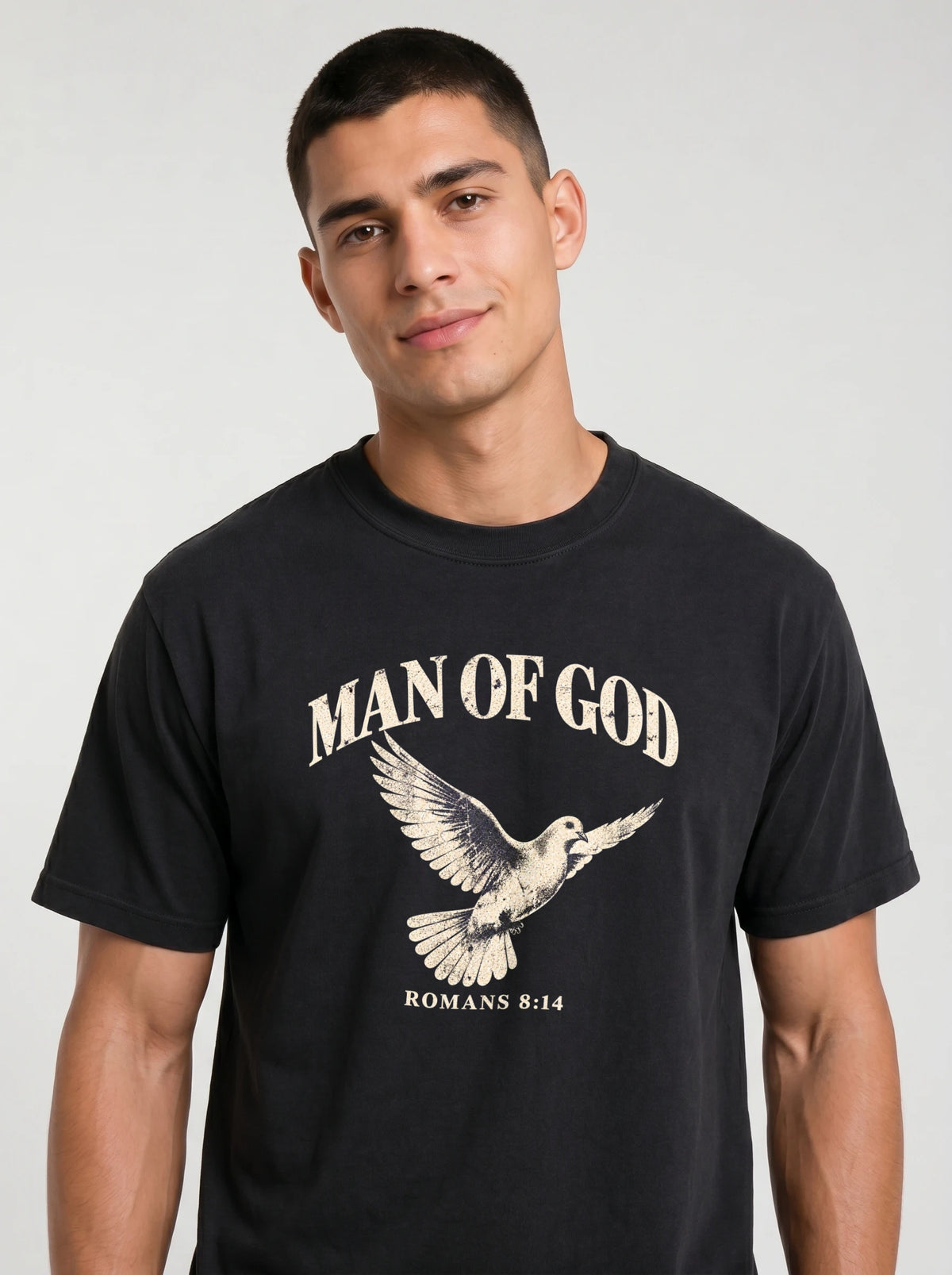 Close-up of a person wearing a black T-shirt with a flying dove and the text “Man of God” and “Romans 8:14.”