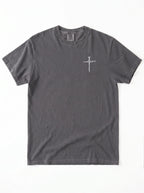 A dark gray crewneck t-shirt with with a small cross printed on the chest, laid flat against a white background.