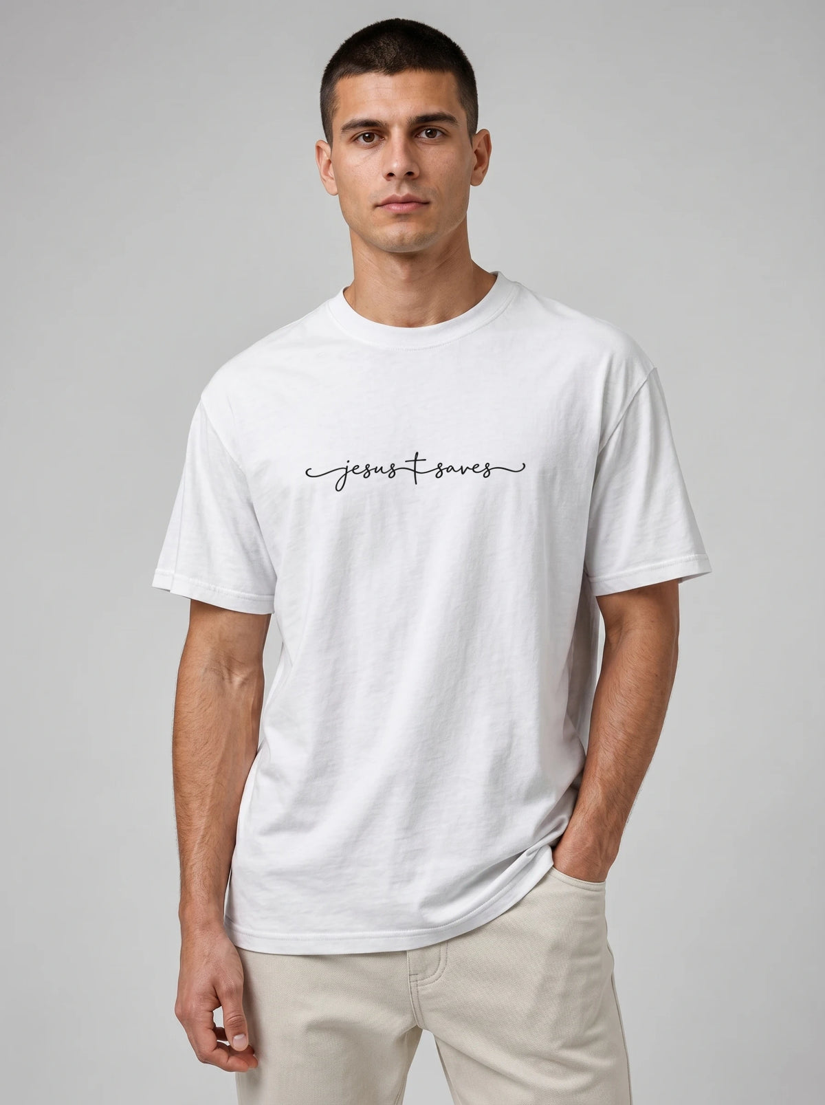 Person wearing a white T-shirt with black script reading “Jesus Saves,” with a cross incorporated into the lettering.