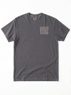 A dark gray short-sleeve t-shirt with the phrase 'GOD IS EVERY WHERE' printed in a light gray or off-white typewriter font on the left chest, displayed flat against a white background.