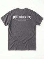 A dark gray t-shirt shown from the back, featuring the text 'Philippians 4:13' in a white gothic font, with smaller text underneath reading 'I CAN DO ALL THINGS THROUGH CHRIST WHO STRENGTHENS ME'.