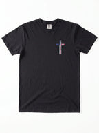 A black short-sleeve crewneck t-shirt with a small cross-shaped American flag graphic on the left chest, displayed flat against a white background.