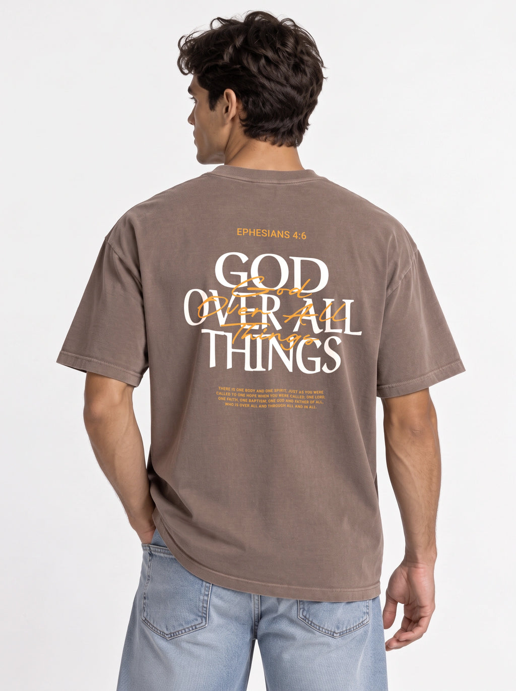 Person modeling the back of a brown T-shirt with “Ephesians 4:6,” a large “God Over All Things” graphic, and Bible verse text.