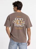 Person modeling the back of a brown T-shirt with “Ephesians 4:6,” a large “God Over All Things” graphic, and Bible verse text.