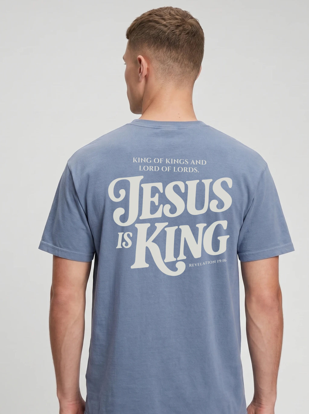 Person wearing a faded light blue T-shirt with back text: “King of Kings and Lord of Lords. Jesus is King. Revelation 19:16.”