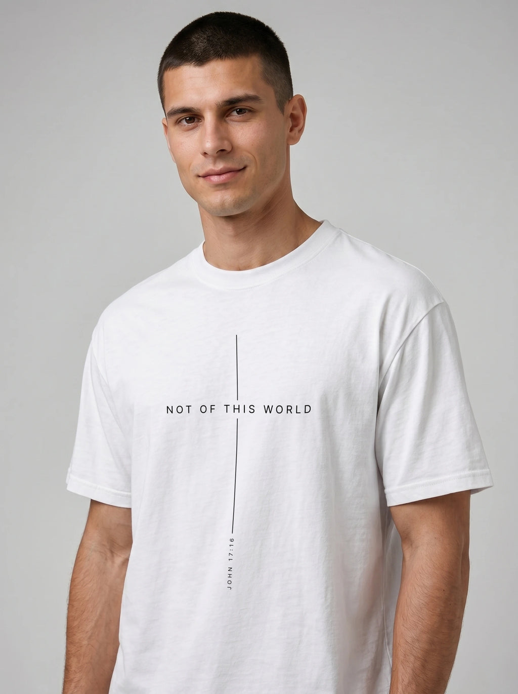 Person wearing a white T-shirt with thin black lines framing the text “Not of This World” and “John 17:16.”