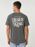 Person wearing a faded gray T-shirt and jeans, showing back text: “King of Kings and Lord of Lords. Jesus is King. Revelation 19:16.”