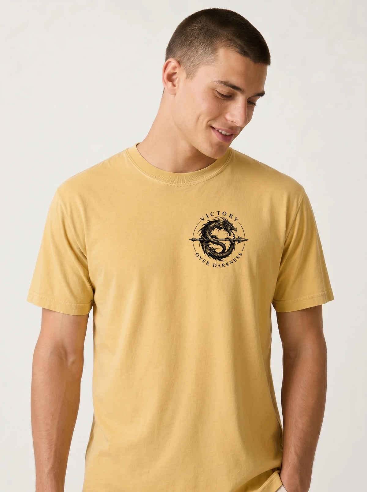 Yellow T-shirt with a small circular dragon graphic and the text “VICTORY OVER DARKNESS” on the chest.