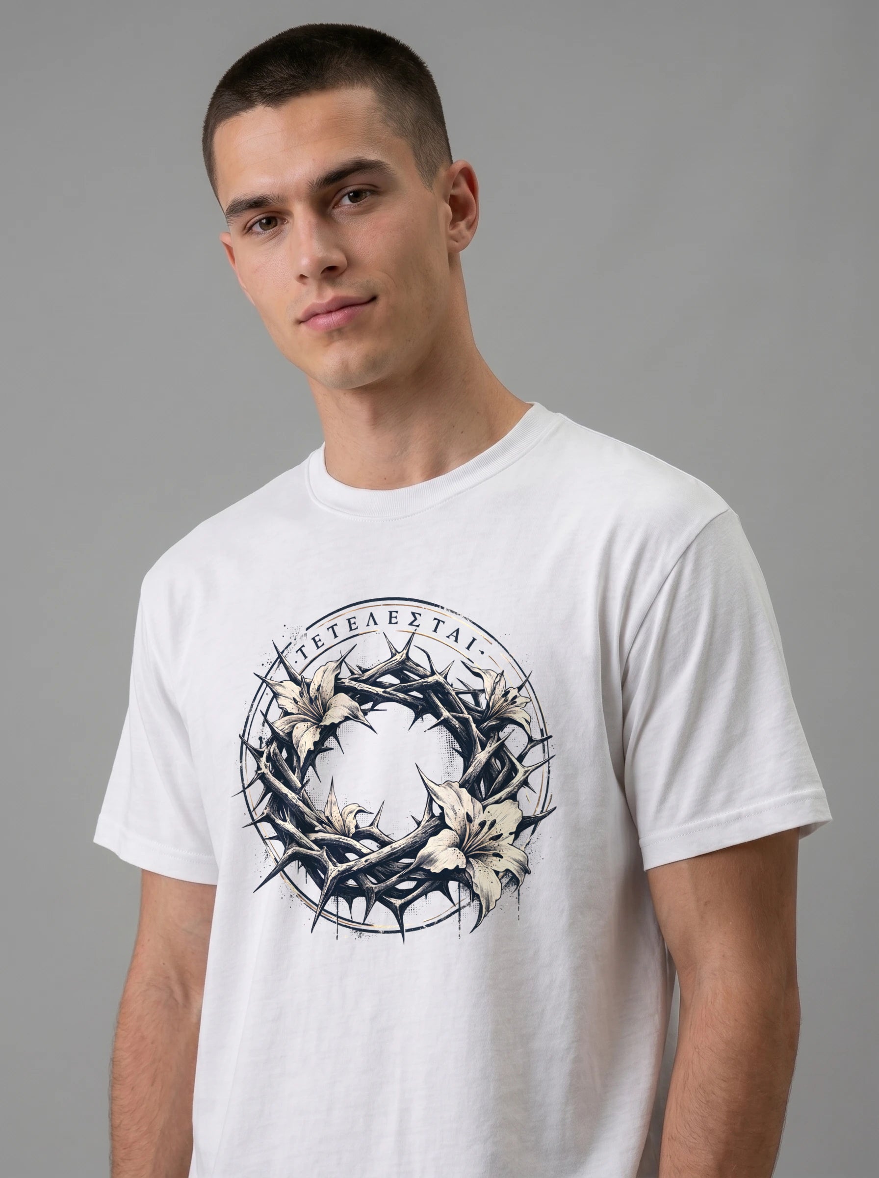 A man wearing a white crewneck t-shirt with a graphic print of a crown of thorns and white lilies, featuring Greek text.
